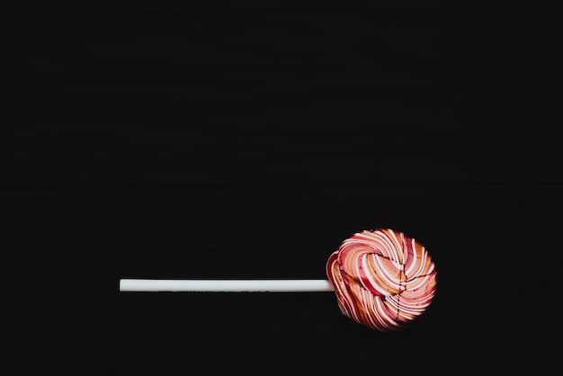 Red round colored Lollipop on black background