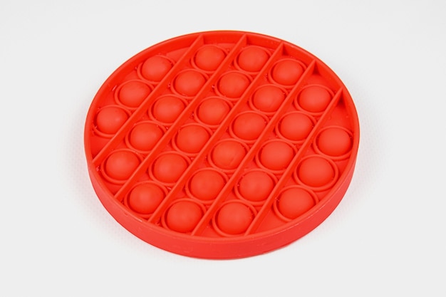 Red round Fidget Toy Pop-it on the white background. Push Pop Bubble.