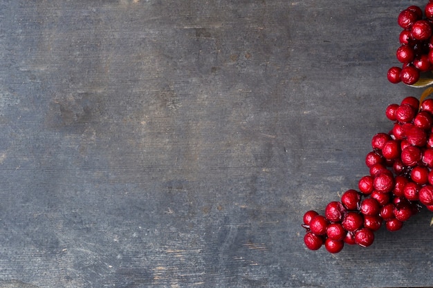 Red rowan berries on vintage rustic wooden background Autumn background with red berries and copyspase christmas background with red berries space for text