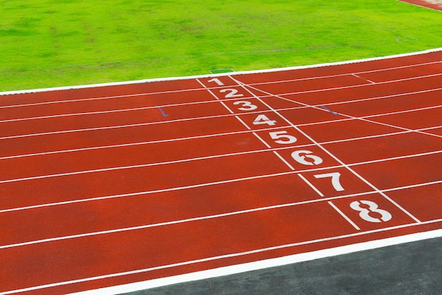 Фото Красная беговая дорожка на стадионе для спортсменов фоне