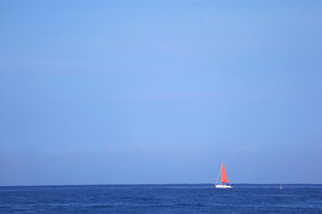 Red Sail Yacht in Sailing on the Deep Blue Ocean