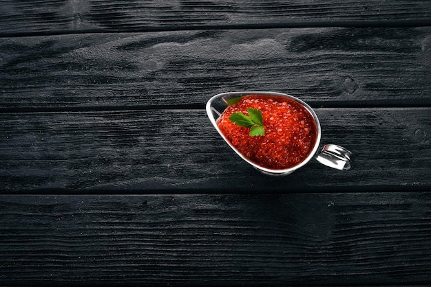 Red salmon caviar On a wooden background Top view Free space for text