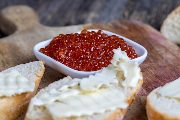 Red salmon or trout caviar with white baguette and butter