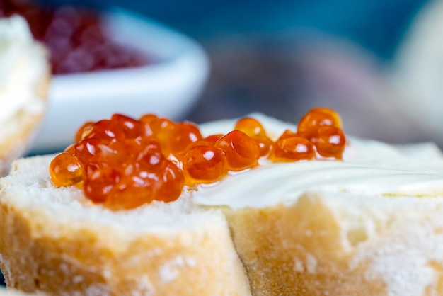 Red salmon or trout caviar with white baguette and butter