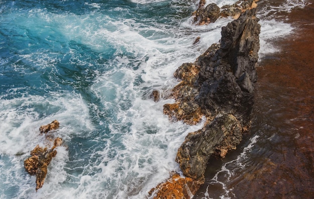 Red sand beach maui in in hawaiian sea wave and rock summer beach background