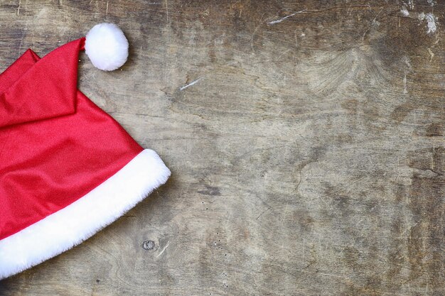 Red santa hat on a textured wooden background