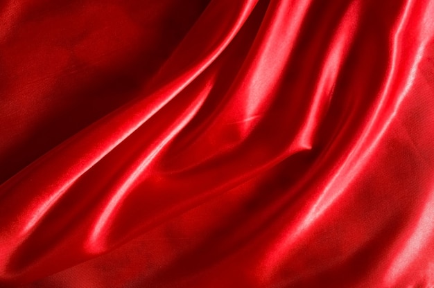 Фото Красная атласная или шелковая ткань в качестве фона.