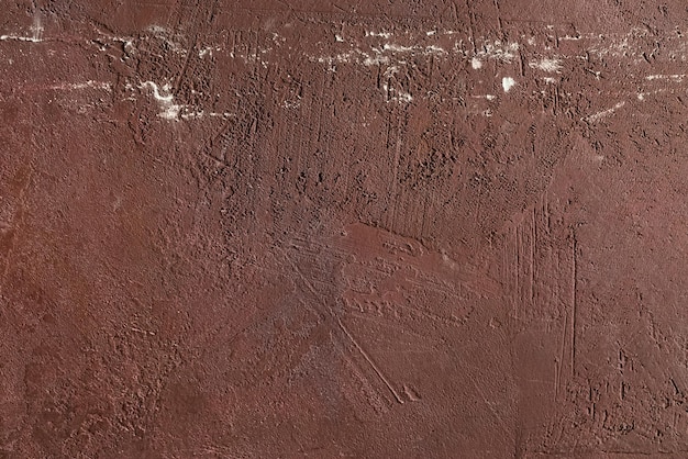 Red scratched and weathered plaster on concrete wall texture. Abstract background