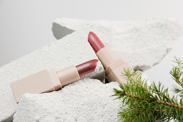 red shining lipsticks on natural stones background cosmetics christmas sale or winter holidays special offer selective focus holiday make up concept minimal style decor