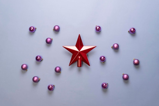 A red shiny christmas star with balls flat lay abstract layout