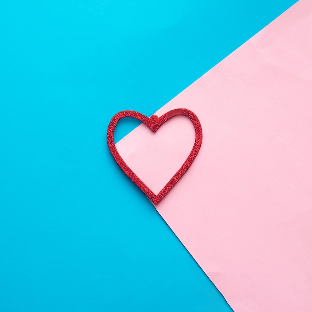 Red shiny heart  on pink and blue background