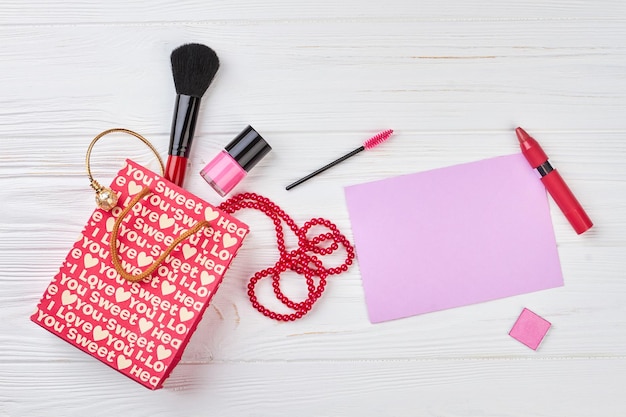 Red shopping bag and makeup accessories.