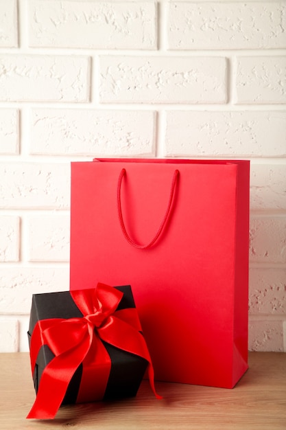 Foto sacchetto della spesa rosso con regalo su sfondo chiaro. venerdì nero. vista dall'alto