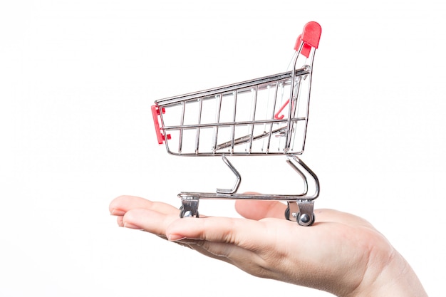 Red shopping cart trolley on hand isolated on white .