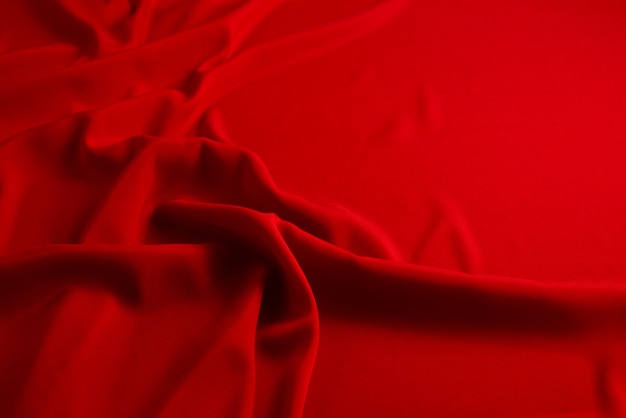 Red silk or satin luxury fabric texture background. Top view