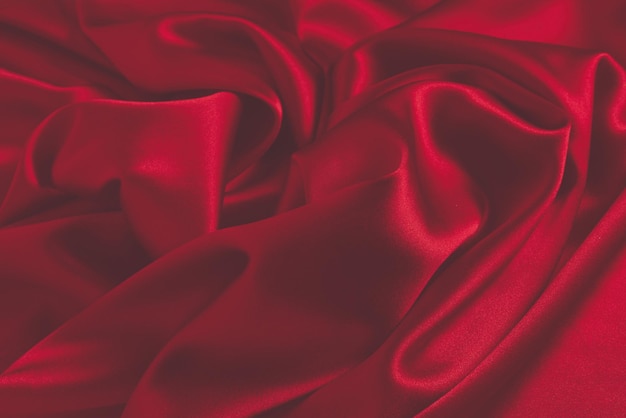 Red silk or satin luxury fabric texture can use as abstract background. Top view.