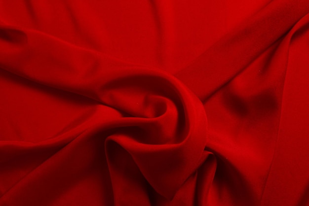 Red silk or satin luxury fabric texture can use as abstract background. Top view.