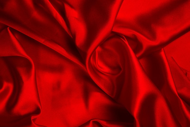 Red silk or satin luxury fabric texture can use as abstract background. Top view.