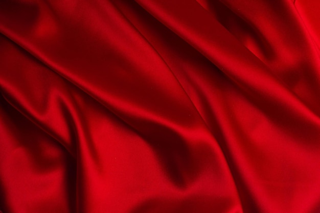 Red silk or satin luxury fabric texture can use as abstract background. Top view.