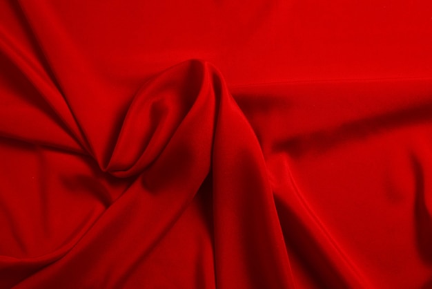 Красный шелк или атласную роскошную текстуру ткани можно использовать в качестве абстрактного фона Вид сверху