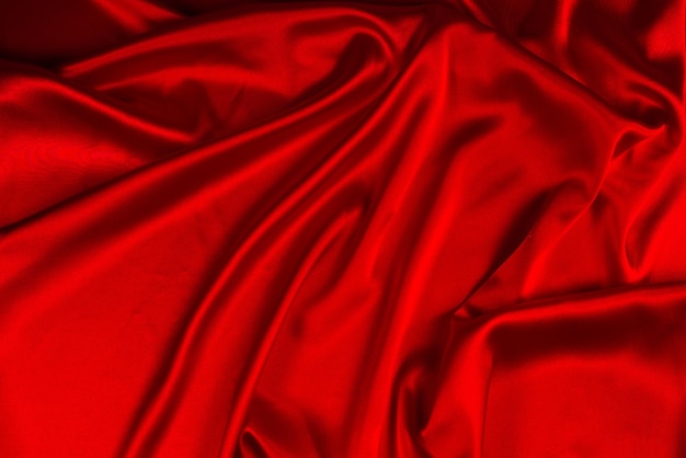 Красный шелк или атласную роскошную текстуру ткани можно использовать в качестве абстрактного фона Вид сверху