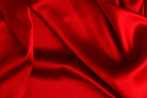 赤い絹またはサテンの豪華な生地の質感は、抽象的な背景として使用できます。上面図