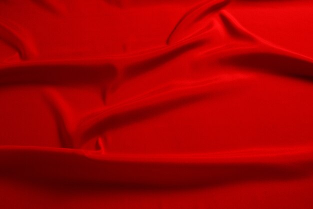 Red silk or satin luxury fabric texture can use as abstract background. Top view.