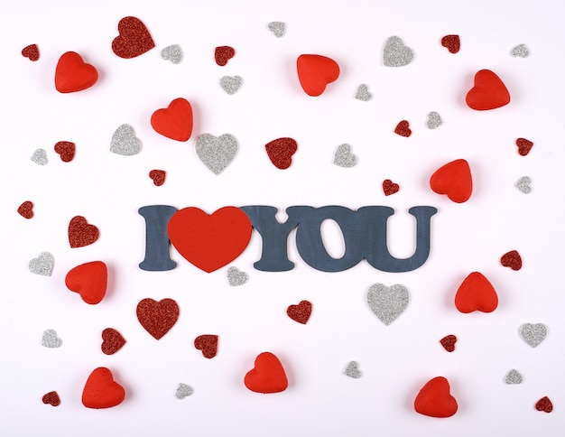 red and silver hearts on a white background around the inscription I love you. Valentines day.