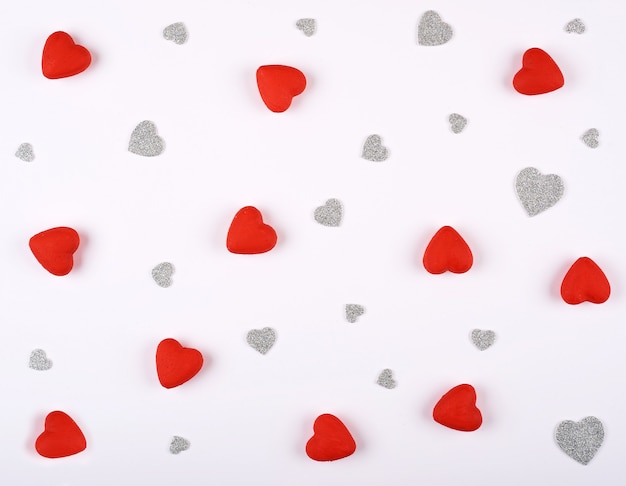 Red and silver hearts on a white background