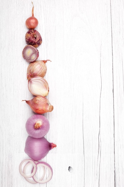 Red slice onion bulb on white wood table