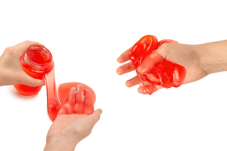 Photo red slime toy in woman hand isolated on white