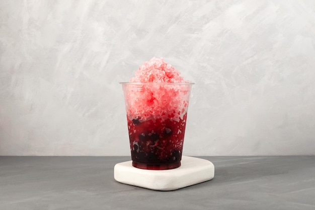 Red Slushie drink with natural juice Sweet berries shaved ice in disposable plastic cup