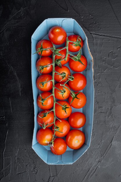 Red small cherry tomatoes, on black background