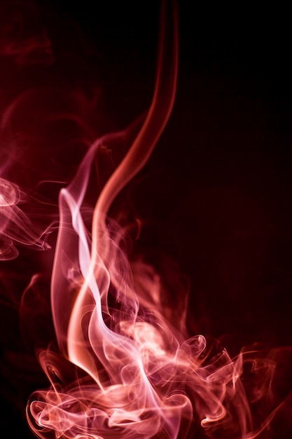 Foto movimento di fumo rosso su sfondo nero.