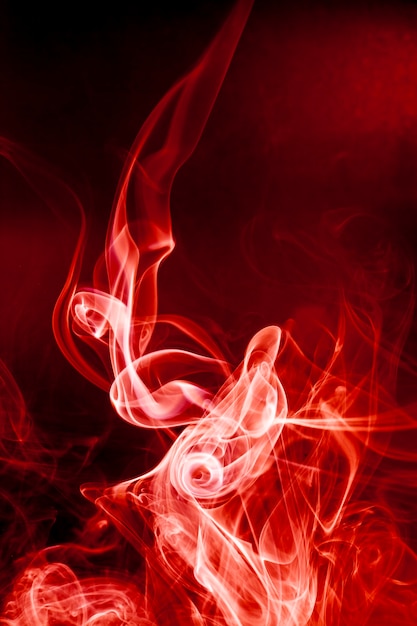 Foto movimento di fumo rosso su sfondo nero.