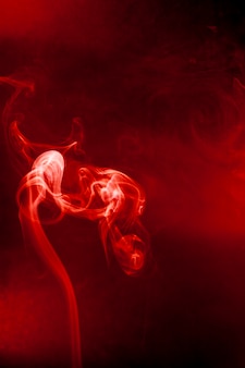 Movimento di fumo rosso su sfondo nero.