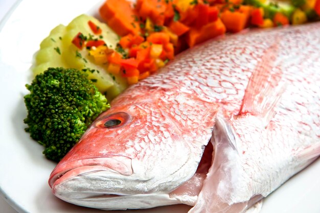 red snapper or fresh snapper ready to be cooked with steamed vegetables food gastronomy raw