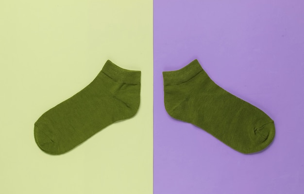 Red socks on colored background. Pastel color trend. Top view