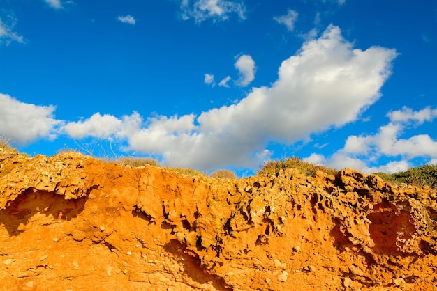 Red soil under a blue sky with clouds Shot in Alghero Italy