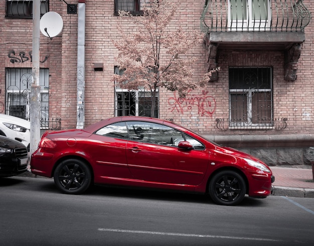 Foto automobile sportiva rossa su uno sfondo di strada cittadina