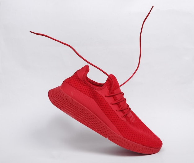 写真 白い背景の上のフライングレースと赤いスポーツ靴