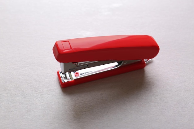 Red stapler on light background