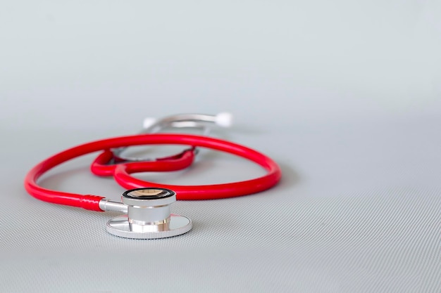 A red stethoscope on a gray surface