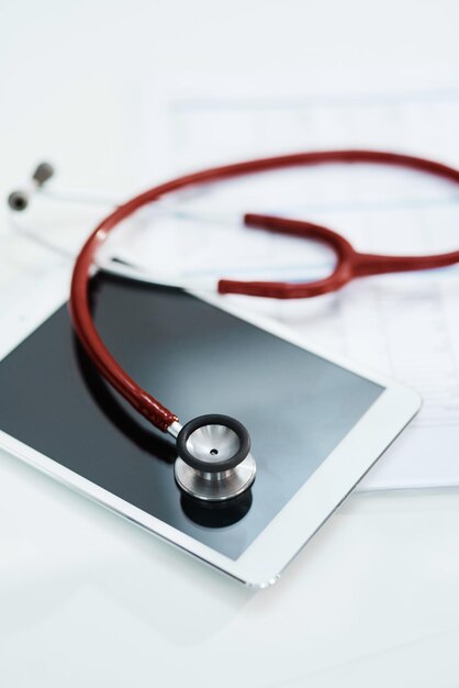 a red stethoscope is laying on a white surface