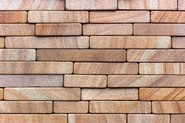 Red stone wall decorated with sandstone tile. Background or texture