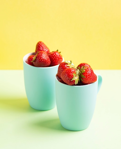 Red strawberries in blue circles on a light green and yellow lime background