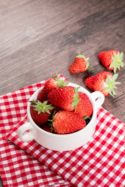 Photo red strawberries isolated in bowl on table