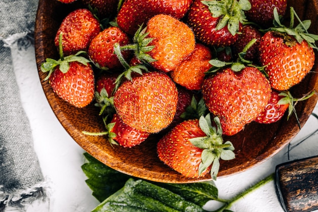 Red strawberries on a light wooden background