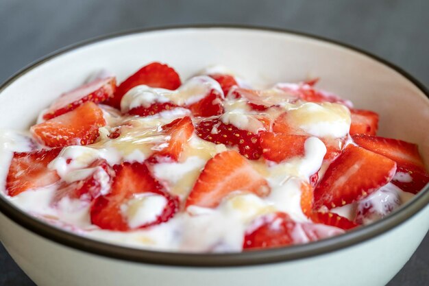 Brulée allo yogurt bianco e fragola rossa. dessert di frutta a colazione con spicchi di fragola perfettamente matura di stagione, primo piano