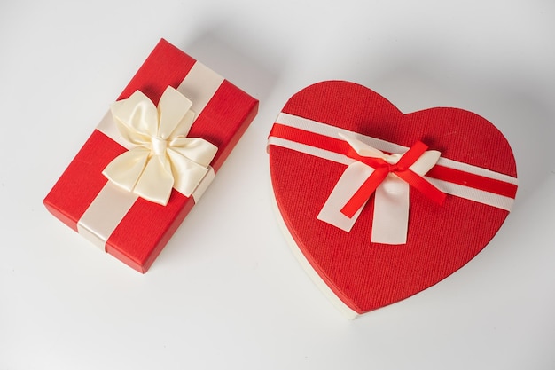 Red and striped boxes with gifts tied bows on white background